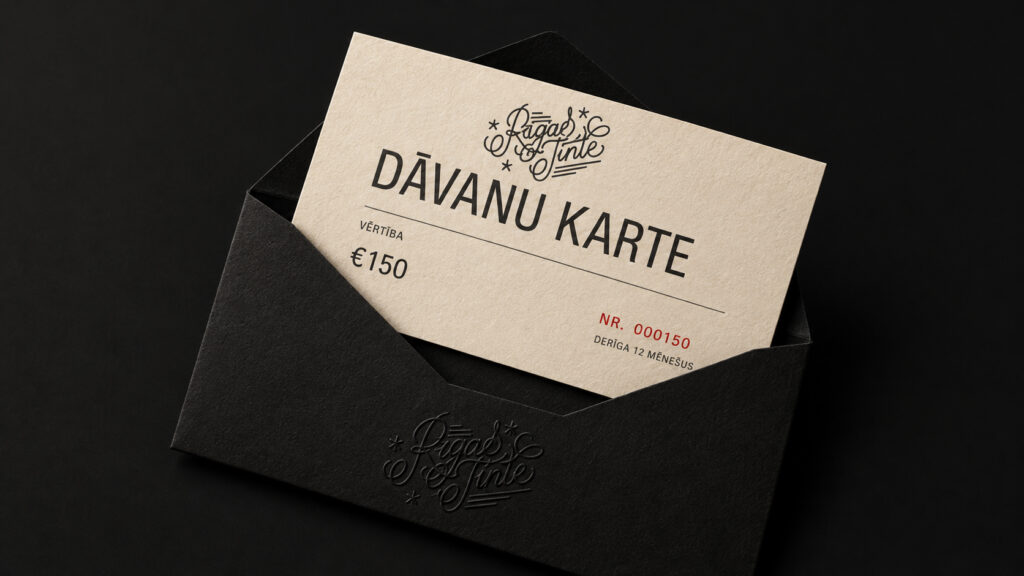 A Rīgas Tinte gift card for €150 in a black envelope