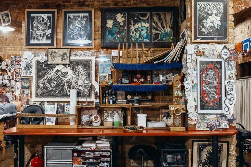A tattoo artist's workstation at Rīgas Tinte with drawings on the wall
